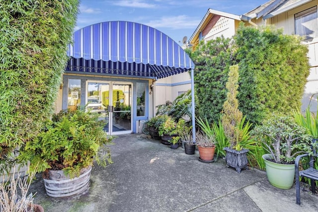 property entrance featuring a patio and french doors