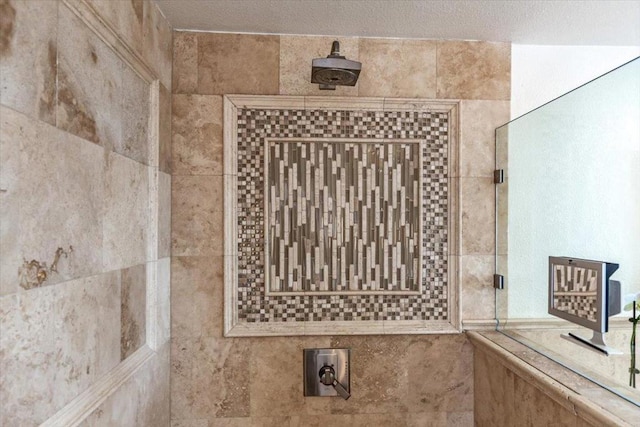 bathroom with a tile shower and a textured ceiling