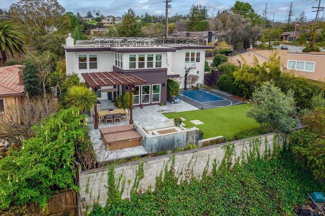 rear view of house featuring a patio, a yard, basketball hoop, and a pergola