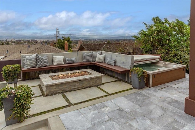 view of patio / terrace featuring a hot tub and a fire pit