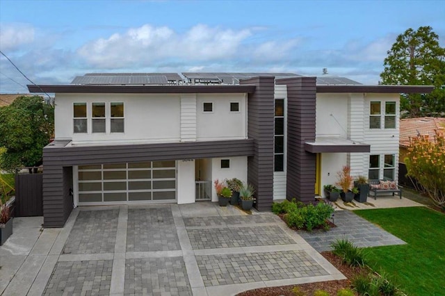 view of front of home featuring cooling unit, a garage, and solar panels