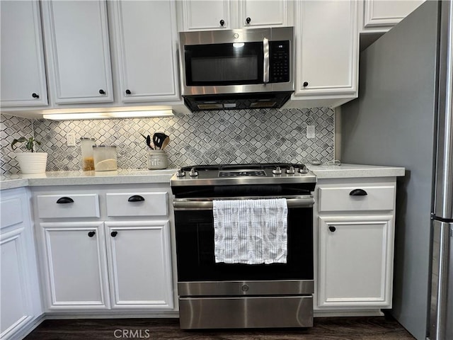 kitchen featuring stainless steel appliances, white cabinetry, and tasteful backsplash