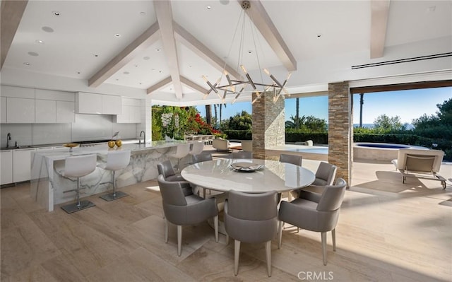 dining space with lofted ceiling with beams, sink, and light wood-type flooring