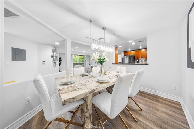 dining area with hardwood / wood-style floors and electric panel