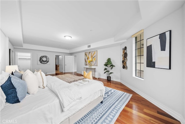 bedroom featuring hardwood / wood-style floors and a tray ceiling