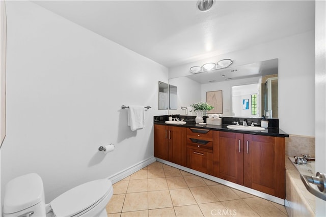 bathroom featuring vanity, a relaxing tiled tub, tile patterned floors, and toilet