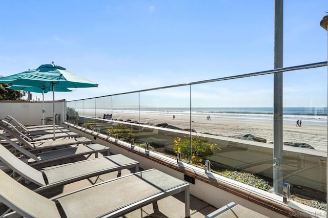 balcony with a water view and a beach view