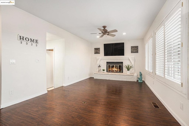 unfurnished living room with dark hardwood / wood-style flooring, a fireplace, and ceiling fan