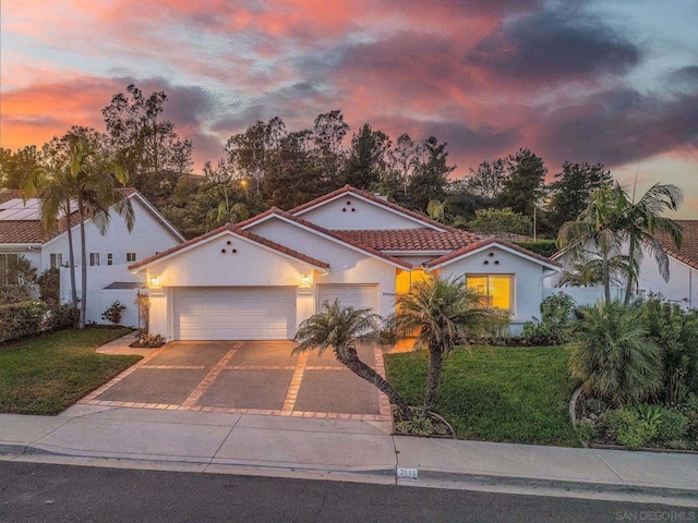 mediterranean / spanish house with a garage and a yard