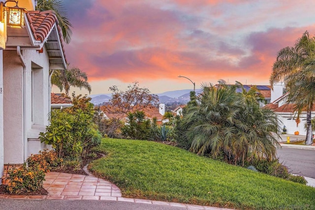 yard at dusk featuring a mountain view