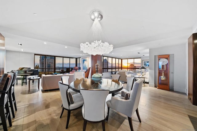 dining room with floor to ceiling windows, light hardwood / wood-style flooring, and a notable chandelier