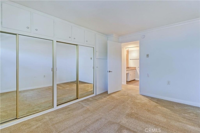 unfurnished bedroom featuring ornamental molding, two closets, and light colored carpet