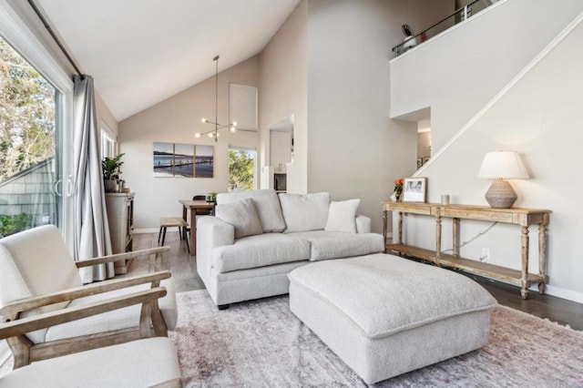 living room with hardwood / wood-style flooring, a chandelier, and high vaulted ceiling