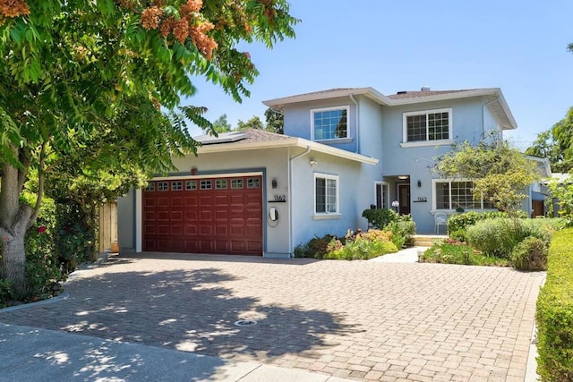 view of front of property featuring a garage and solar panels