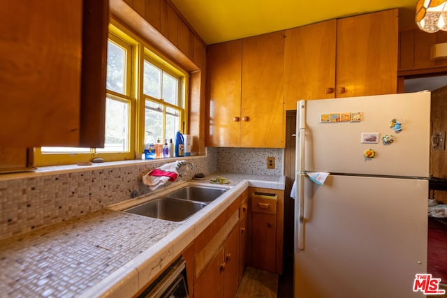 kitchen with tasteful backsplash, sink, and white fridge