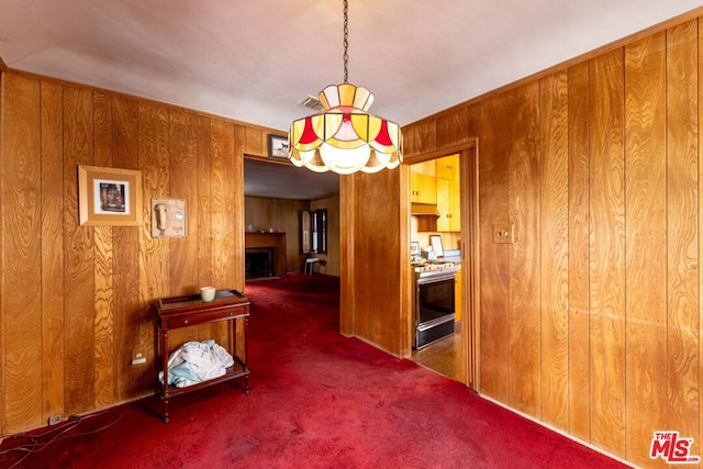 unfurnished dining area with dark carpet and wood walls