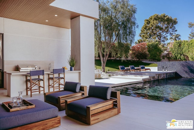 view of patio with an outdoor kitchen, area for grilling, and an outdoor fire pit