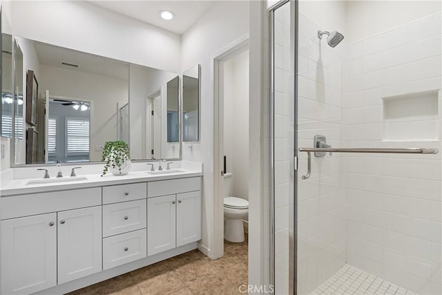 bathroom with vanity, ceiling fan, a shower with door, and toilet