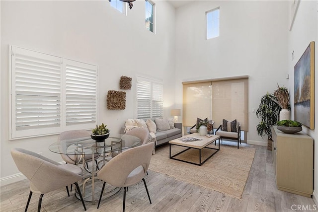 living room with a towering ceiling and light hardwood / wood-style floors