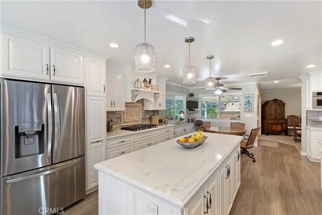 kitchen featuring pendant lighting, appliances with stainless steel finishes, and white cabinets