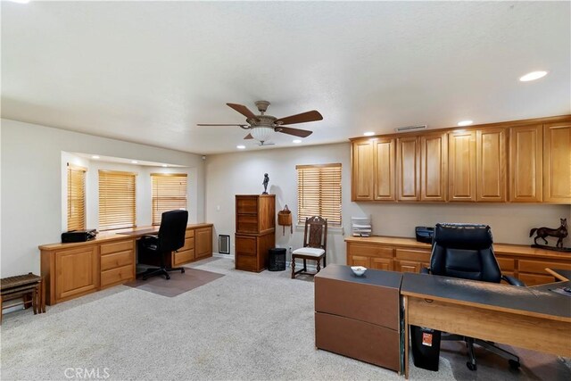 carpeted office space with ceiling fan