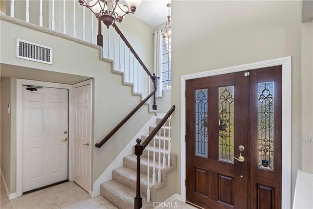 foyer with a towering ceiling and light tile patterned floors