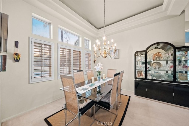 dining space featuring a notable chandelier and a tray ceiling