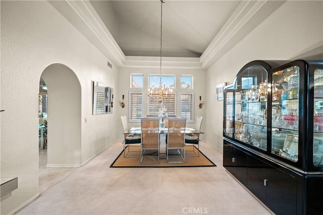 unfurnished dining area featuring light colored carpet, a tray ceiling, a chandelier, and vaulted ceiling