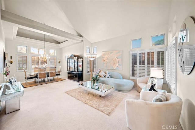 carpeted living room with a raised ceiling, plenty of natural light, a notable chandelier, and high vaulted ceiling