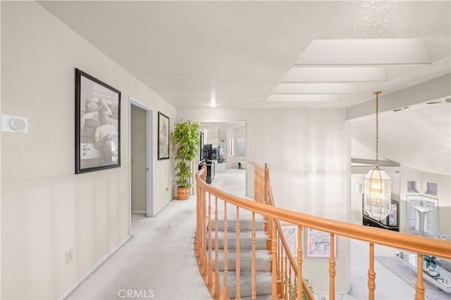 hallway with vaulted ceiling and light colored carpet