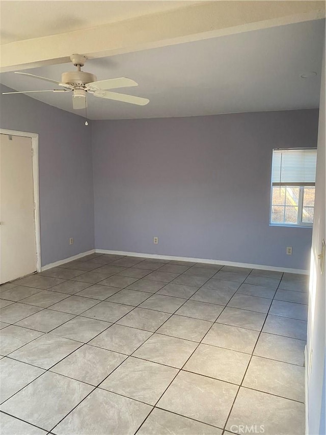 empty room with vaulted ceiling with beams, light tile patterned floors, ceiling fan, and baseboards