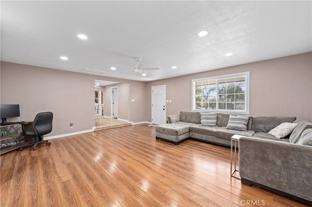 living area with light wood-style floors, baseboards, and recessed lighting