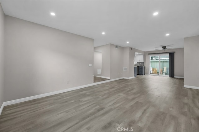 unfurnished living room featuring ceiling fan and light hardwood / wood-style floors