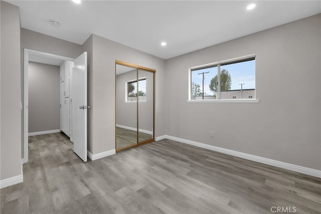 unfurnished bedroom featuring light hardwood / wood-style flooring and a closet