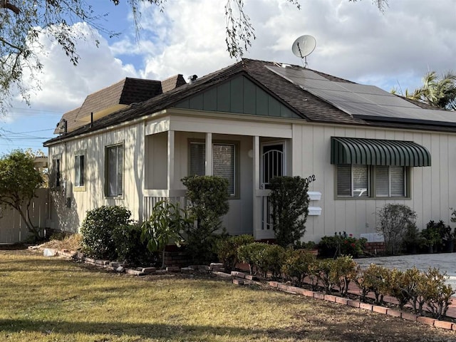 view of front of house featuring a front yard and solar panels