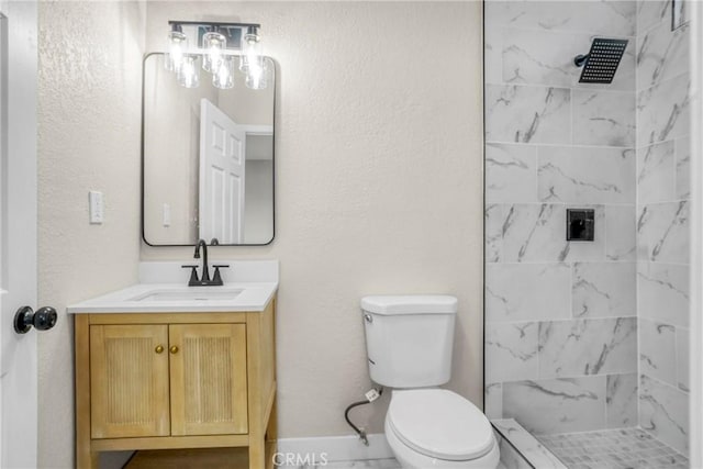 bathroom featuring vanity, toilet, and a tile shower