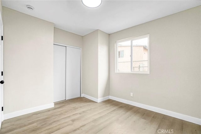 unfurnished bedroom with a closet and light hardwood / wood-style flooring