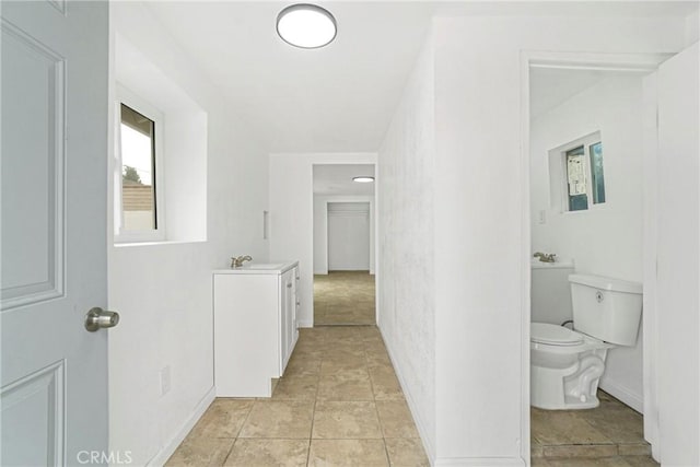 hall with sink and light tile patterned floors