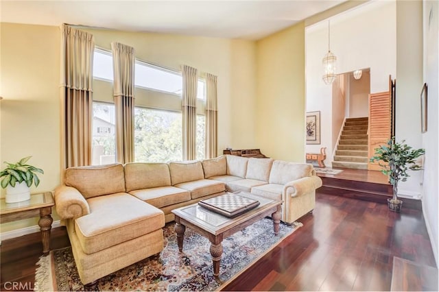 living room featuring a high ceiling and dark hardwood / wood-style flooring