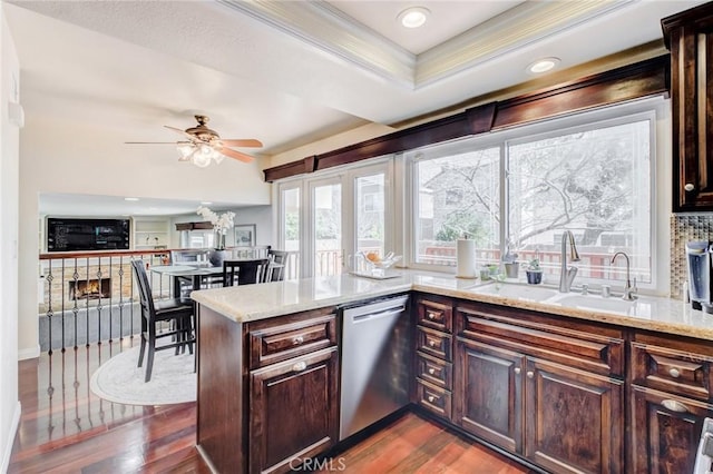 kitchen featuring crown molding, dark hardwood / wood-style floors, dishwasher, kitchen peninsula, and light stone countertops