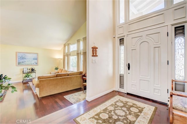 foyer entrance with high vaulted ceiling and dark hardwood / wood-style floors