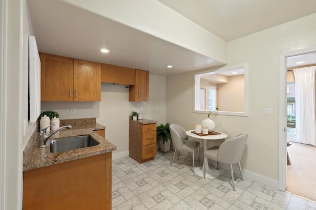 kitchen featuring light stone countertops and sink