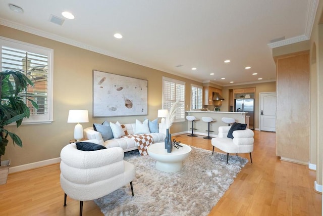 living room featuring ornamental molding and light wood-type flooring