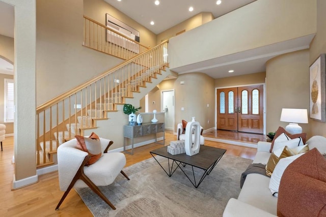 living room with a towering ceiling and light hardwood / wood-style floors