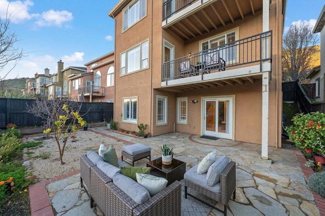 rear view of property with an outdoor living space and a patio