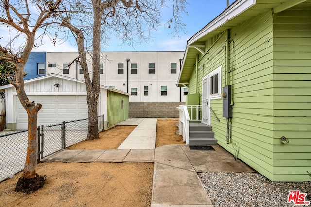 exterior space featuring a garage and an outbuilding