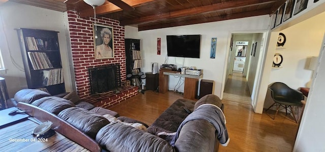 living room with wood ceiling, wood-type flooring, a fireplace, and lofted ceiling with beams