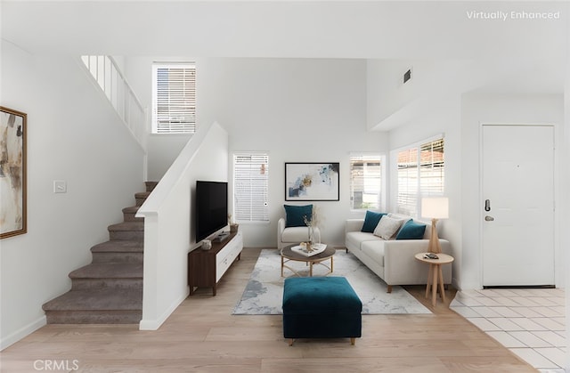 living room with a high ceiling and light hardwood / wood-style flooring