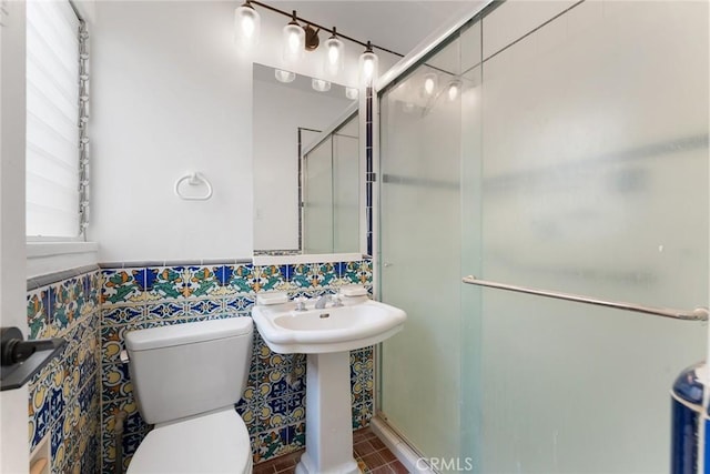 bathroom featuring sink, tile walls, an enclosed shower, and toilet