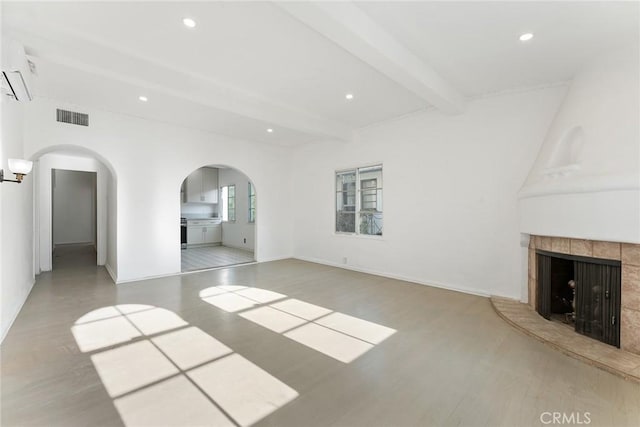 unfurnished living room with beamed ceiling and light hardwood / wood-style flooring